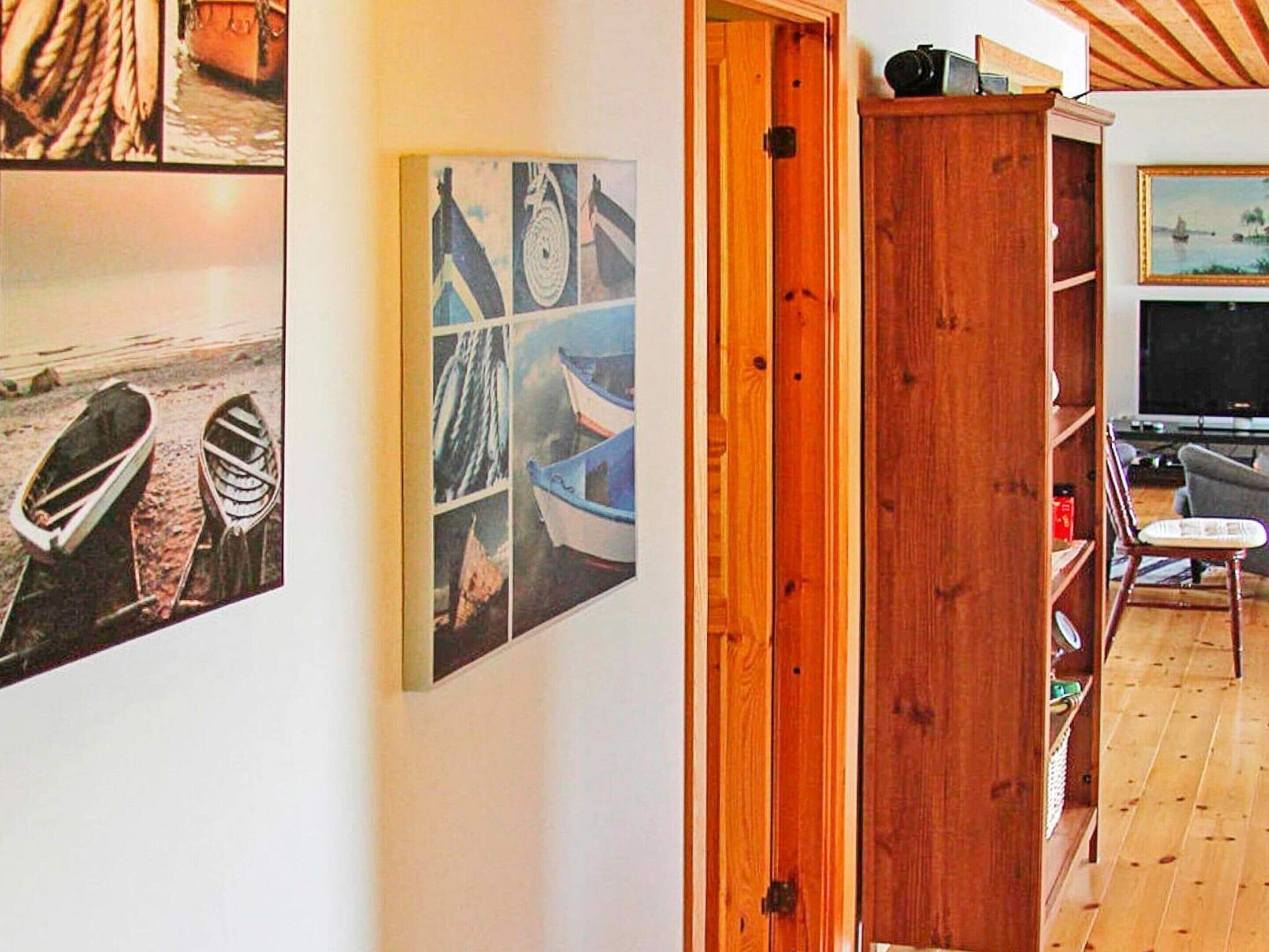 A room with a wooden ceiling, a television, and a bookshelf.