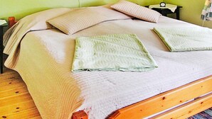 A bed with a wooden frame, two pillows, a blanket, and a bedside table with a lamp. - 6 Person Holiday Home in Vena (Hultsfred)