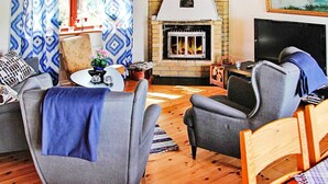 A living room with a fireplace, a television, and a cozy seating arrangement. - 6 Person Holiday Home in Vena (Hultsfred)