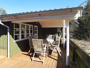 Relax in the serene outdoor patio, complete with a table and chairs, and enjoy the view of the surrounding greenery.