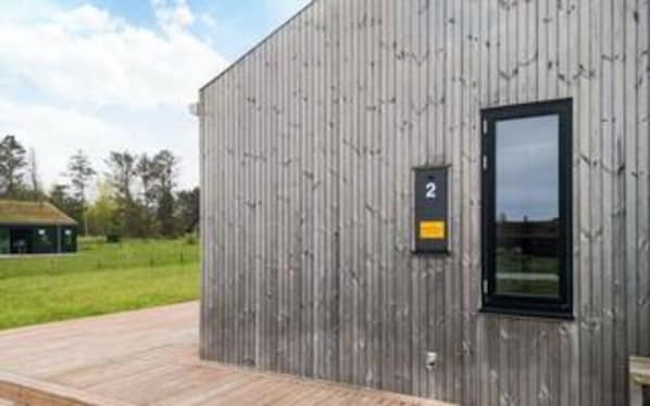 A modern building with a wooden exterior, a black-framed window, and a small sign with the number '2'. - 5 Star Holiday Home in Saltum (Saltum)