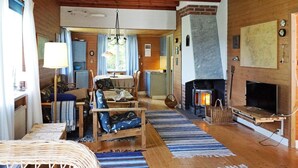 Una sala de estar acogedora con chimenea, muebles de madera y un comedor.