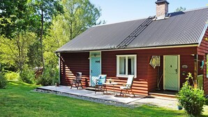 Una casa de madera con un porche, una puerta y una ventana.