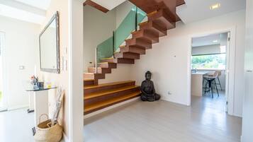 Un interior moderno con una escalera, una estatua y un área de comedor.