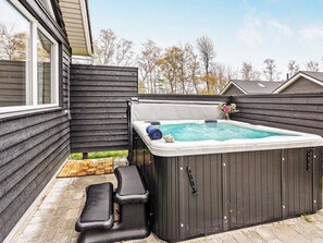 Boblebad med trin, en træterrasse og et hus i baggrunden.