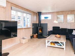 A cozy living room with a fireplace, a television, and a sofa. - 4 Star Holiday Home in Grenaa (Grenaa)