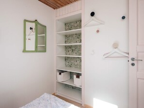 A bedroom with a wardrobe, a mirror, and a bed. - 4 Star Holiday Home in Grenaa (Grenaa)