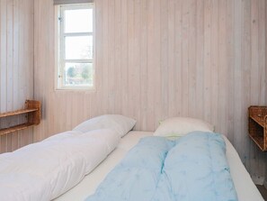 A room with two beds, a window, and wicker furniture. - 4 Star Holiday Home in Grenaa (Grenaa)