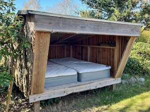 A wooden cabin with a loft-style bed, built-in shelves, and a sloped roof. - 4 Star Holiday Home in Grenaa (Grenaa)