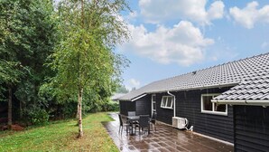 Una propiedad residencial con un patio cubierto, un pequeño espacio de estar al aire libre y un jardín.