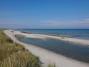 A beach with clear skies, a sandy shore, and people enjoying the water. - 6 Person Holiday Home in Hals (Hals)
