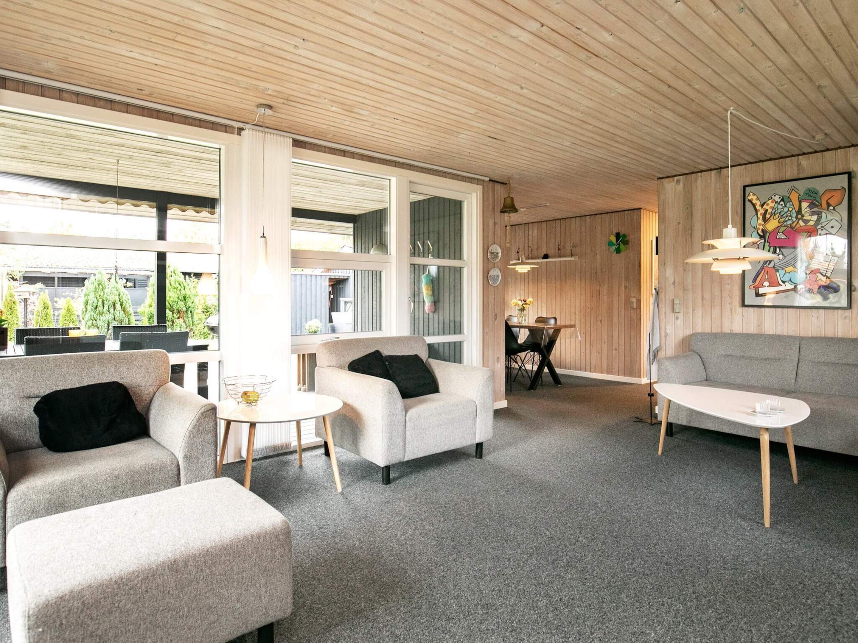 A modern interior with a sofa, armchairs, and a dining table.