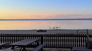 A beach view with a wooden fence, picnic tables, and a calm sea. - 4 Star Holiday Home in Solvesborg (Sölvesborg)