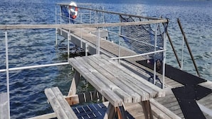 A wooden pier extending into a body of water with a lifebuoy and netting. - 4 Star Holiday Home in Ebeltoft (Ebeltoft)