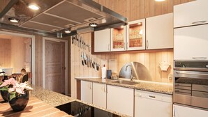 A modern kitchen with granite countertops, stainless steel appliances, and wooden paneling. - 6 Person Holiday Home in Blavand (Blavand)