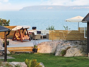 A deck with outdoor seating, a grill, and a view of the water. - 9 Person Holiday Home in Frandefors (Frändefors)