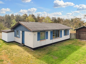 A single-story house with a gabled roof, a small attached garage, and a well-maintained lawn.