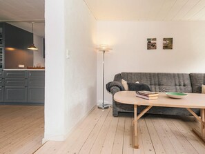 A modern living room with a grey sofa, a wooden coffee table, and a floor lamp.