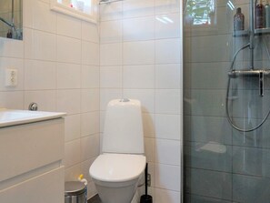 A modern bathroom with a white toilet, a sink, and a glass-enclosed shower. - 6 Person Holiday Home in Aplared-by Traum (Aplared)