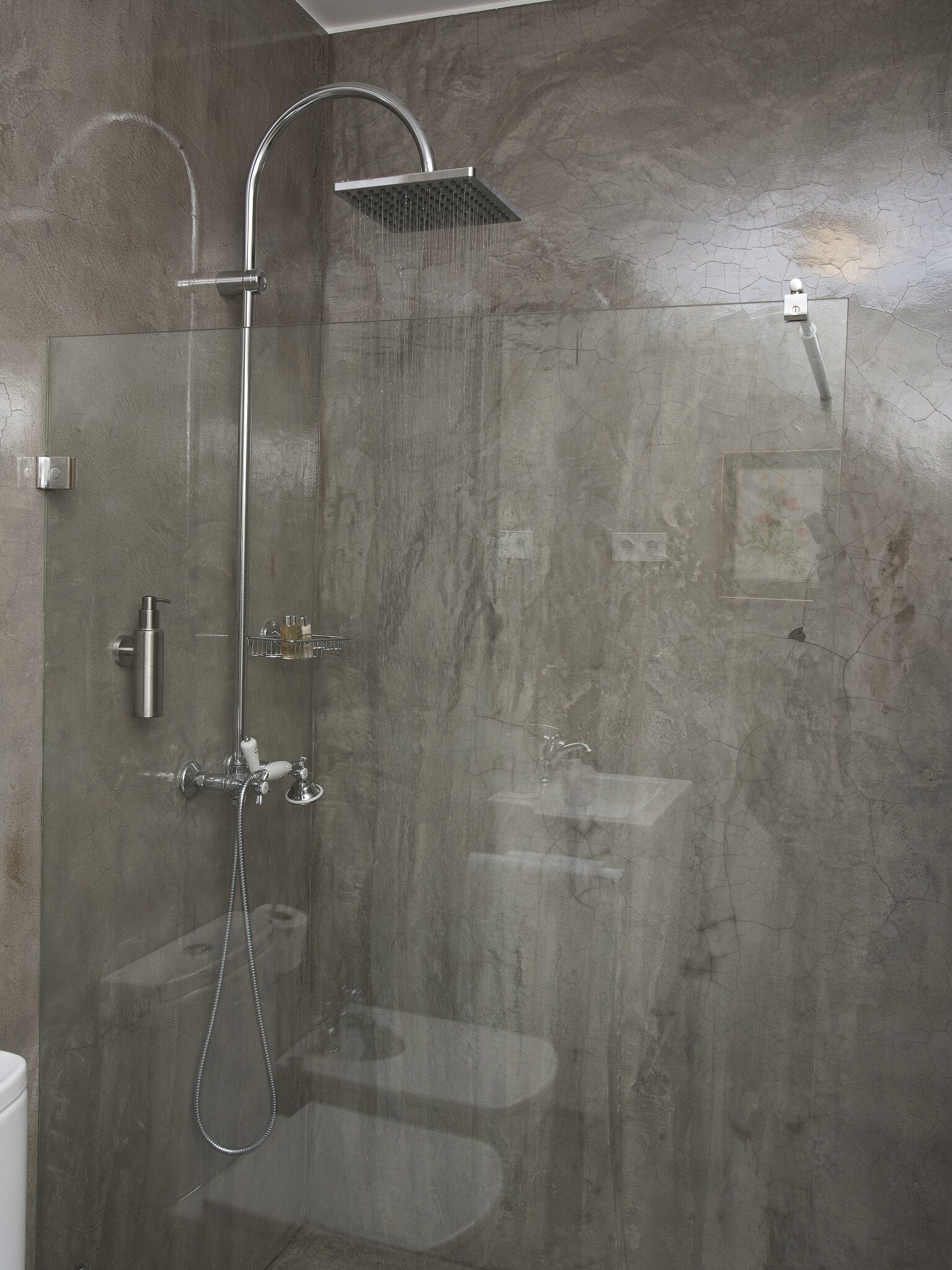 A modern shower with a handheld showerhead and a fixed rain showerhead.