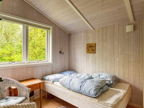 A small, cozy room with a single bed, a desk, and a chair. - 5 Person Holiday Home in Nakskov (Nakskov)