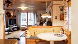 Ett mysigt vardagsrum med en soffa, ett matbord och en tv.