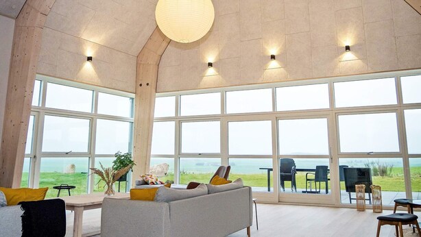 A spacious room with large windows, a high ceiling, and a modern interior design.