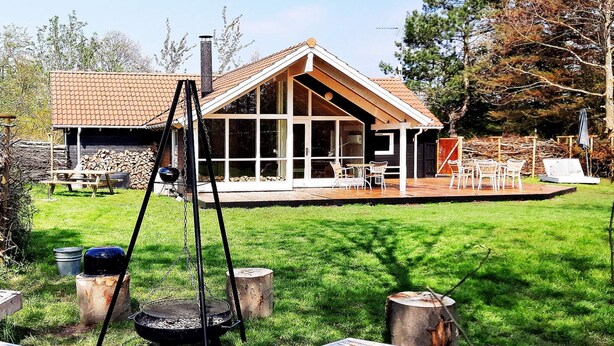 A modern house with a large deck, a swing, and a grill area. - 5 Star Holiday Home in Dannemare (Dannemare)