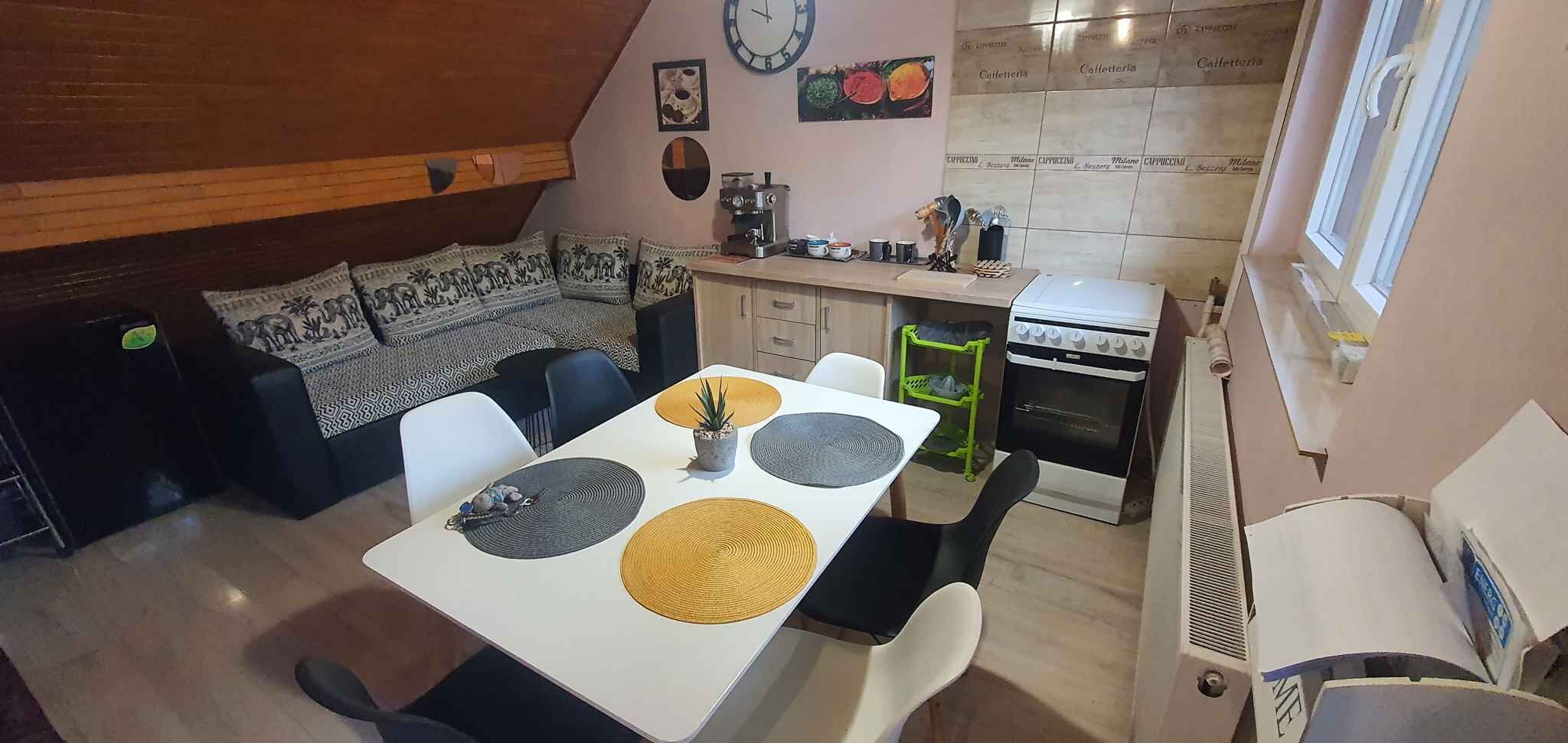 Kompakti keittiö, jossa on ruokailutila sekä liesi, kahvinkeitin ja pieni jääkaappi.