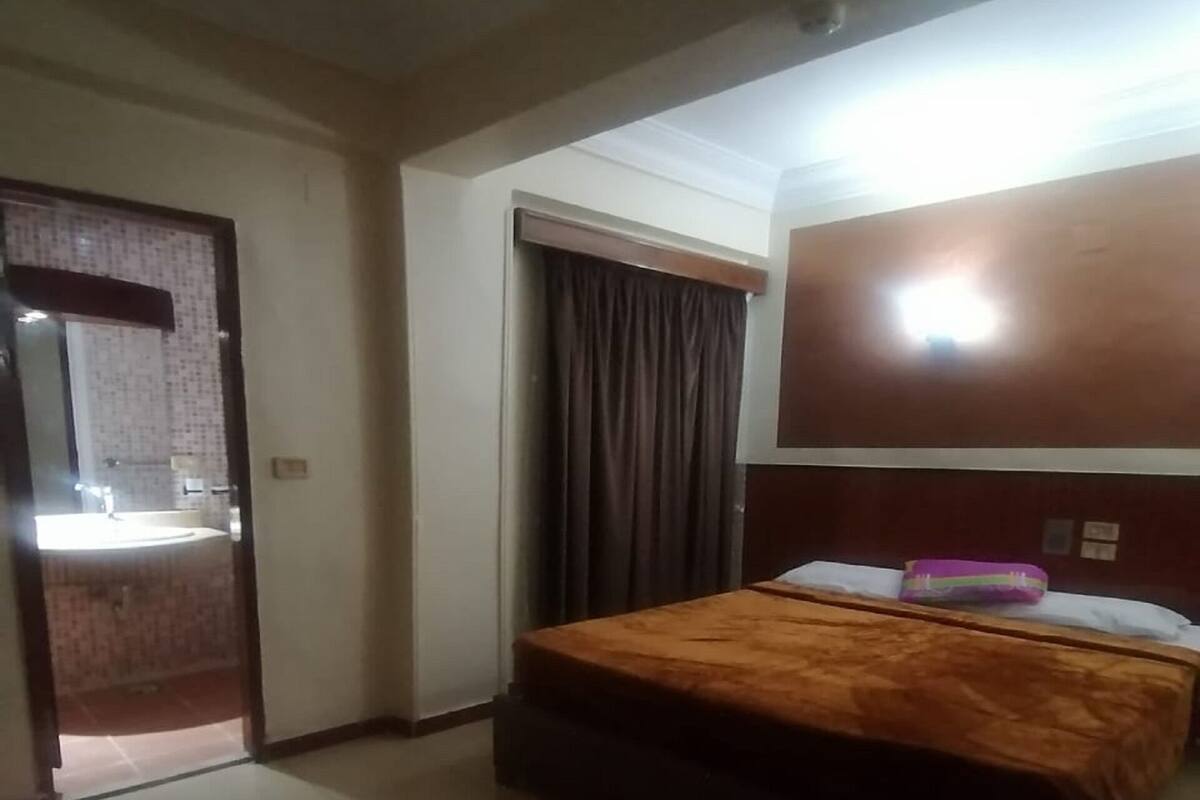 Ein Hotelzimmer mit Bett, Badezimmer mit Waschbecken und Spiegel.