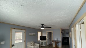 Un salon avec un canapé, une table basse et un ventilateur de plafond.