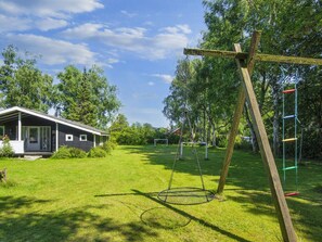 A residential area with a house, a swing set, and a climbing structure. - 6 Person Holiday Home in Glesborg (Glesborg)