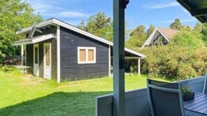 A single-story house with a dark exterior, a visible window, and a door. - 6 Person Holiday Home in Glesborg (Glesborg)