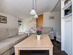 Een woonkamer met twee banken, een houten salontafel en een potplant.