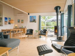 A modern living room with a fireplace, wooden furniture, and a view of the outdoors.