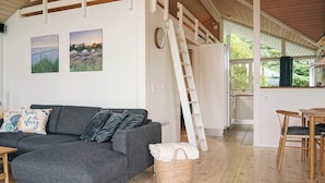 A modern interior with a grey sofa, a woven basket, and a wooden ladder. - 4 Star Holiday Home in Nexo (Nexø)