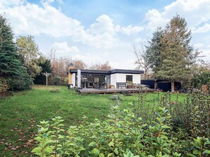 A modern house with a deck, surrounded by a well-maintained lawn and trees. - 5 Person Holiday Home in Gilleleje (Gilleleje)