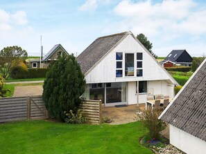 A white two-story house with a sloped roof, a visible front door, and a small porch area. - 5 Person Holiday Home in Otterup (Otterup)