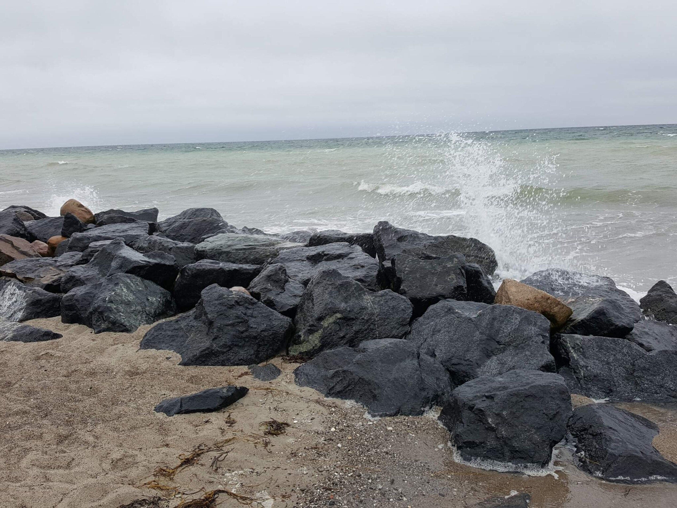 A rocky shoreline with waves crashing against the rocks.