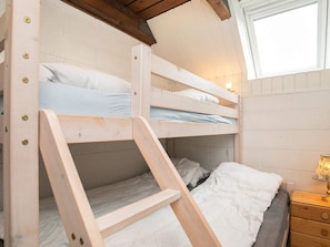A bunk bed room with a wooden ladder, a bedside table with a lamp, and a window. - 5 Person Holiday Home in Otterup (Otterup)