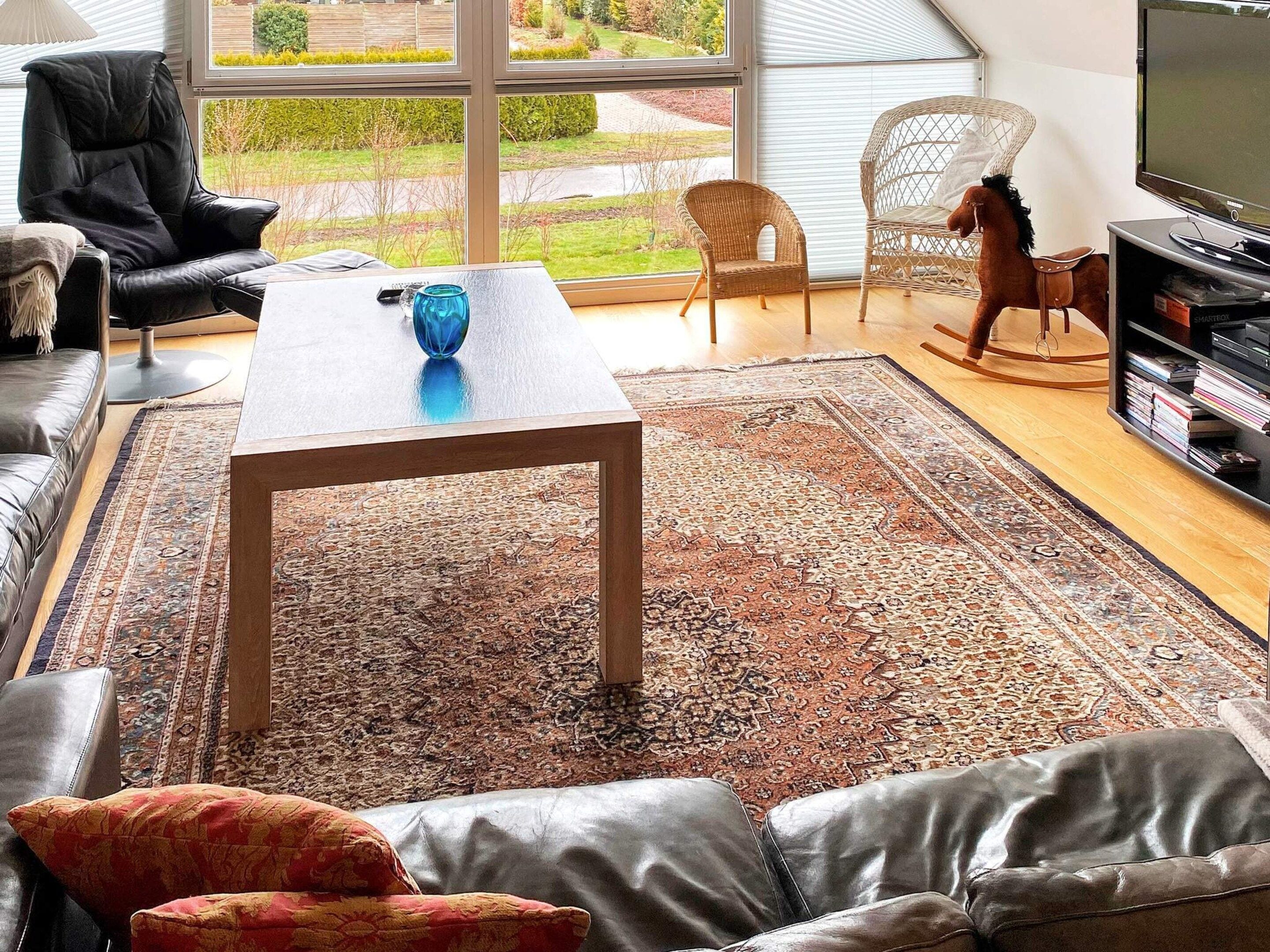 A modern living room with leather sofas, a coffee table, and a television.