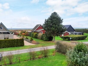 A residential area with houses, a large tree, and a pathway. - 5 Person Holiday Home in Otterup (Otterup)