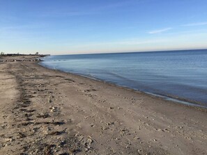 A beach with footprints and a clear sky.