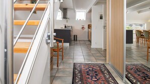 A modern interior with a staircase, a kitchen area, and a dining space. - 5 Person Holiday Home in Otterup (Otterup)