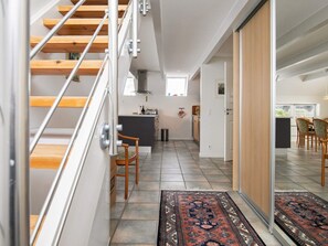 A modern interior with a staircase, a kitchen area, and a dining space. - 5 Person Holiday Home in Otterup (Otterup)