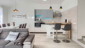 A modern kitchen with grey cabinets, a central island, and pendant lighting. - Holiday apartment with shared pool (Medulin)