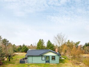A single-story house with a sloped roof, a front door, and a small porch area.