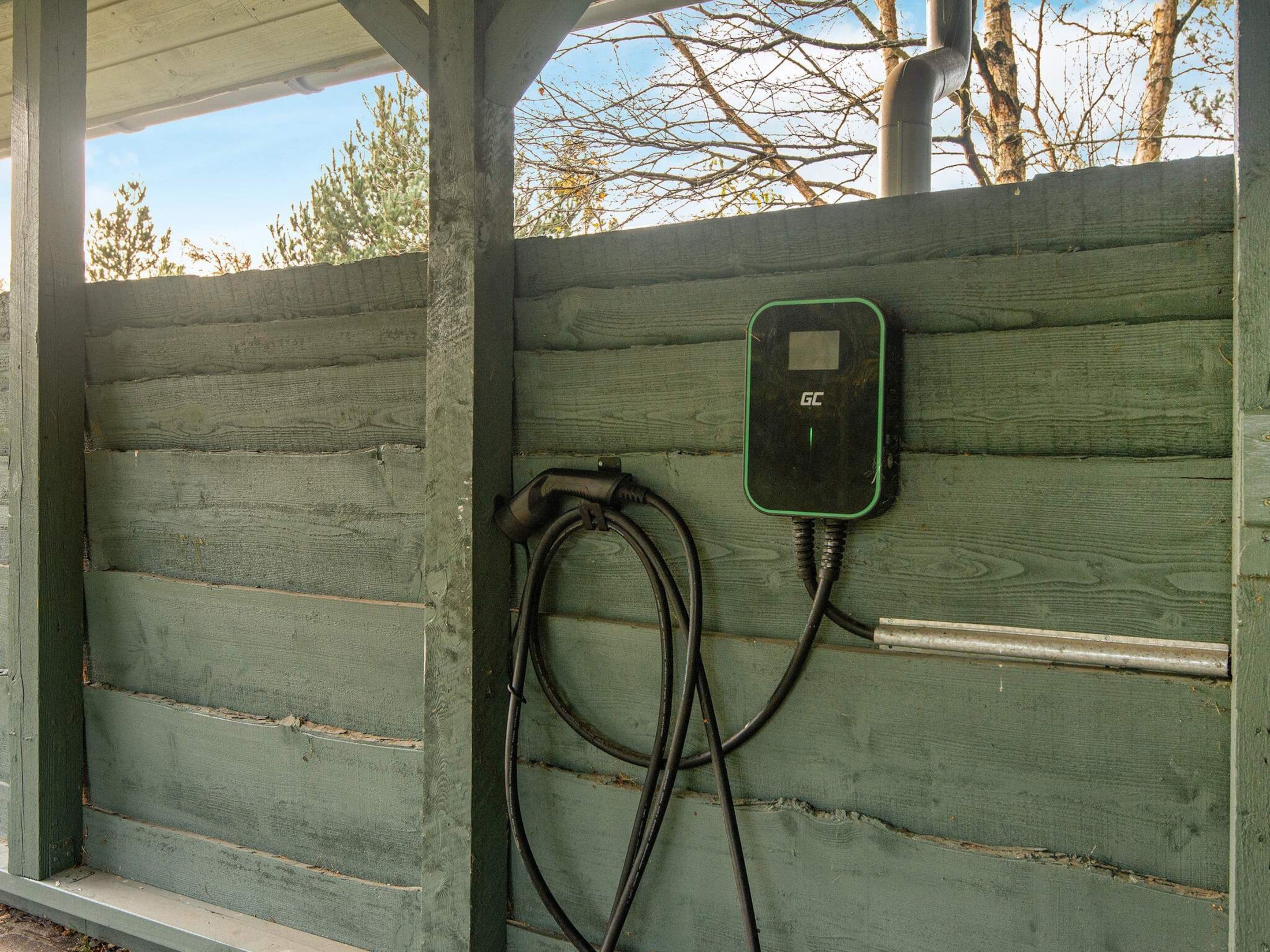 Una estructura verde de madera con un enchufe y cables.
