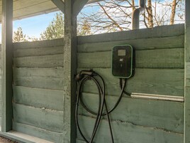 Una estructura verde de madera con un enchufe y cables.