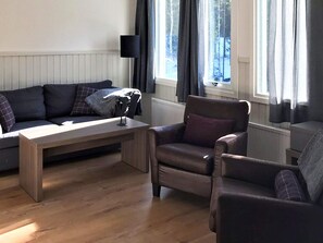 A living room with a sofa, armchairs, a coffee table, and a lamp. - 4 Star Holiday Home in Salen (Salen)